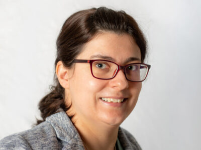 Frau mit Brille und zusammengebundenem Haar.