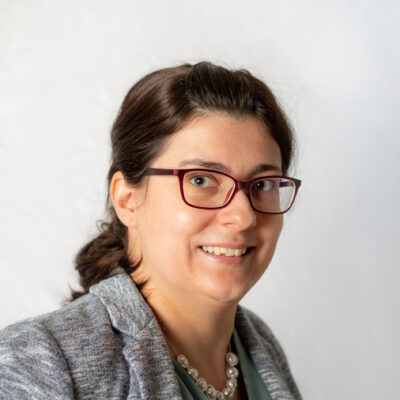 Frau mit Brille und zusammengebundenem Haar.