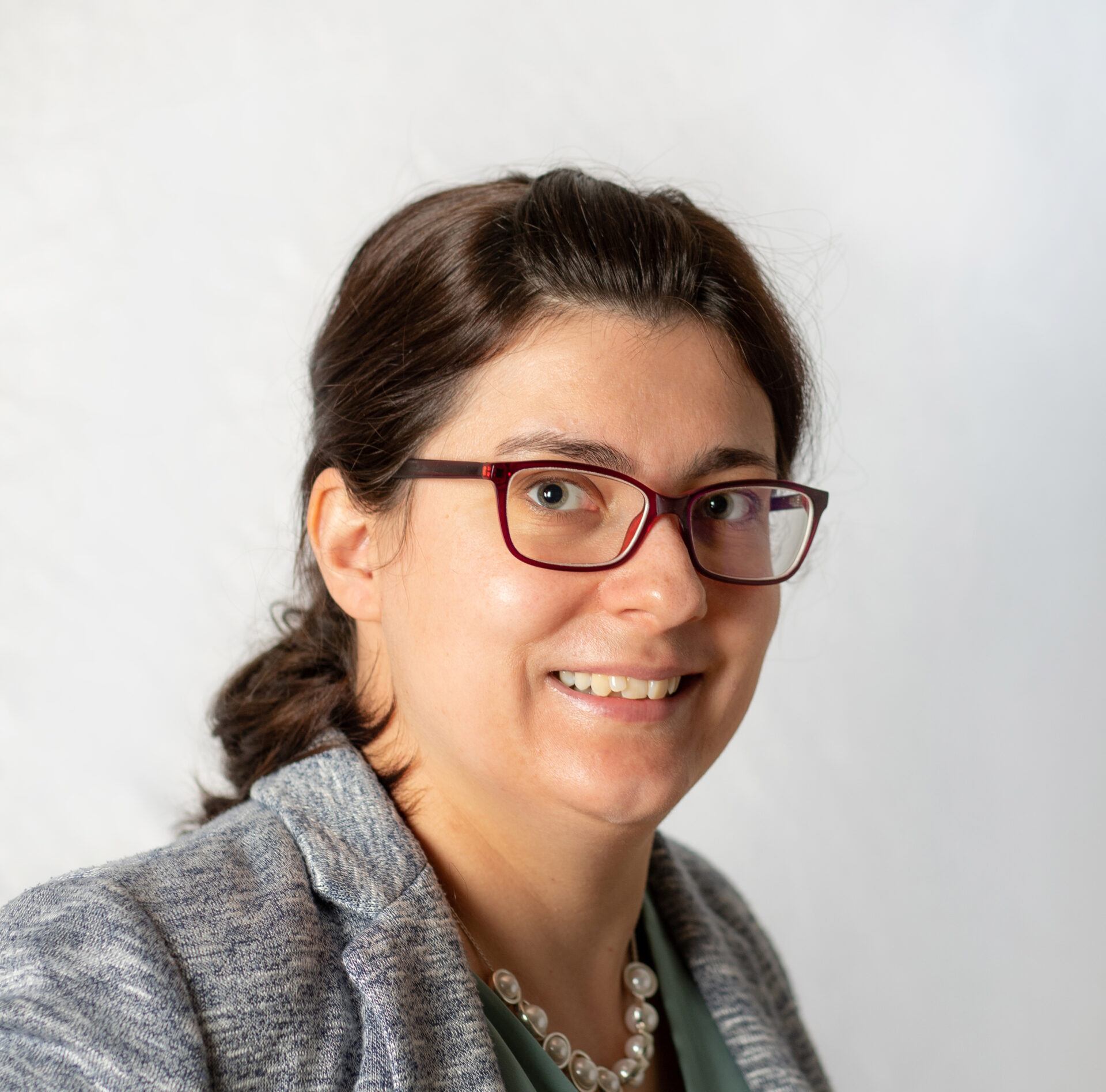 Frau mit Brille und zusammengebundenem Haar.