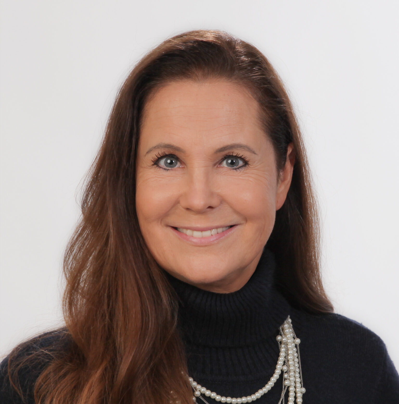 Frau mit langem, braunem Haar lächelt in die Kamera.