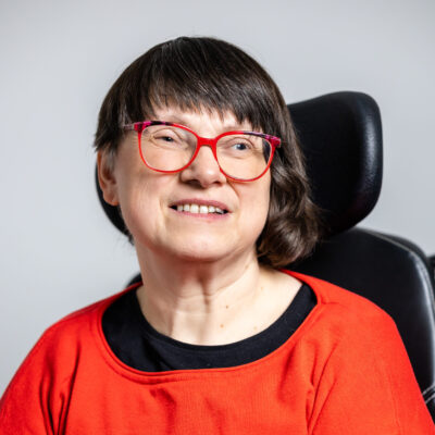 Foto zeigt Frau mit dunklem Haar, die in die Kamera lächelt.