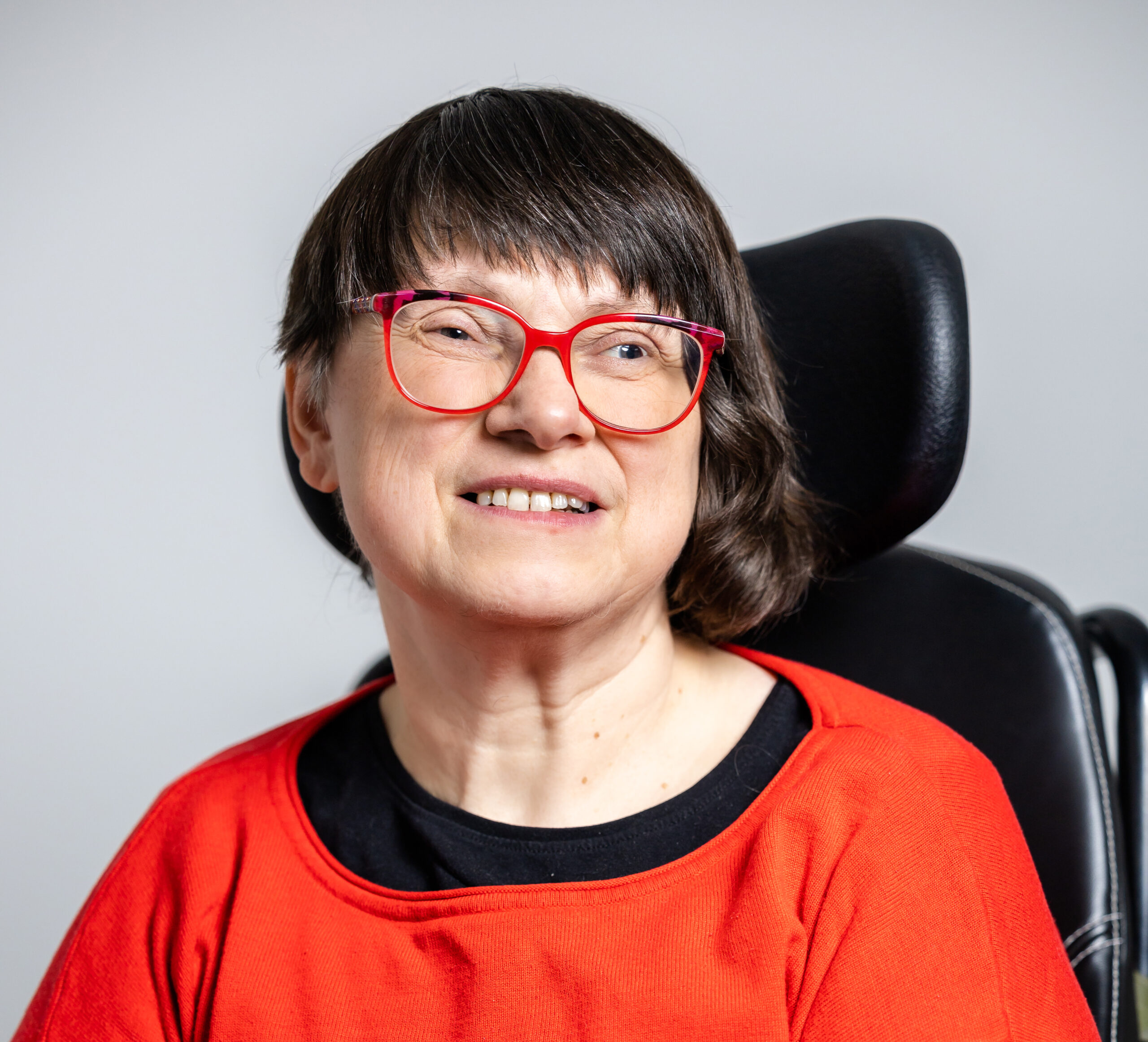 Foto zeigt Frau mit dunklem Haar, die in die Kamera lächelt.