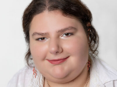 Frau mit zusammengebundenen Haar und weißer Bluse