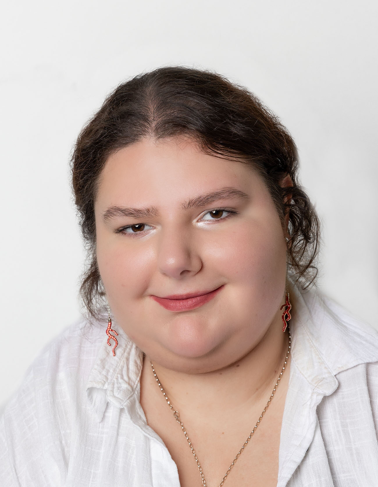 Frau mit zusammengebundenen Haar und weißer Bluse