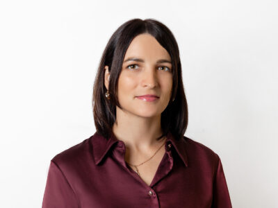 Frau mit dunkelbraunem schulterlangen Haar und roter Bluse