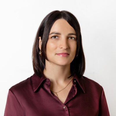 Frau mit dunkelbraunem schulterlangen Haar und roter Bluse