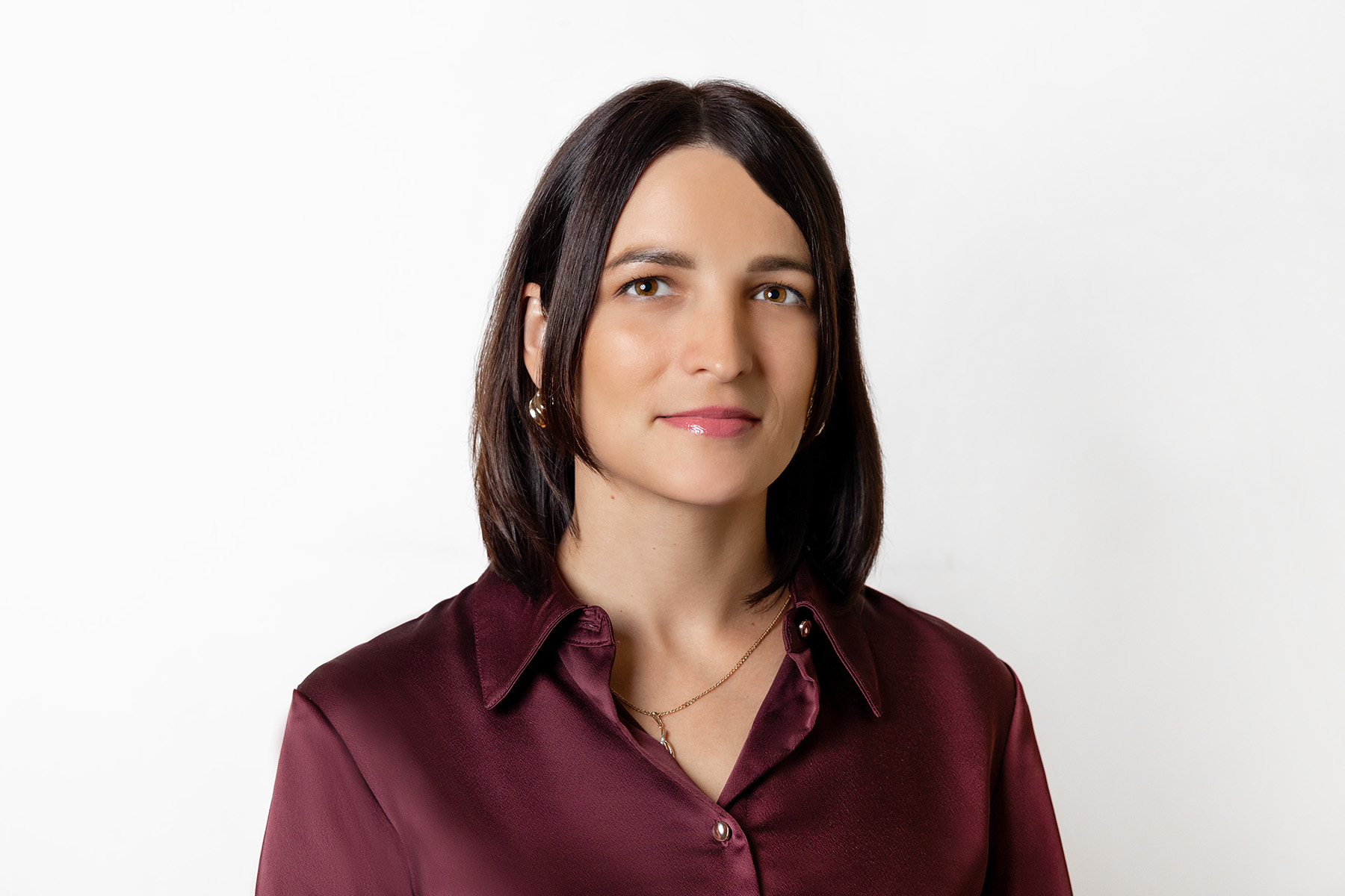 Frau mit dunkelbraunem schulterlangen Haar und roter Bluse