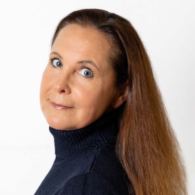 Frau mit langem, braunen Haar trägt ein Oberteil mit Rollgragen