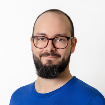 Mann mit Bart und Brille trägt ein blaues T-Shirt